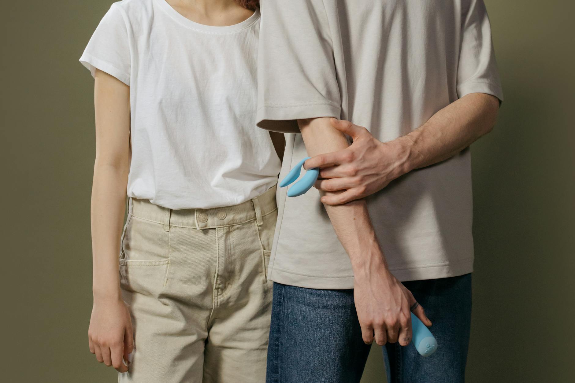 A couple holding a blue vibrator together, showing collaborative intimacy